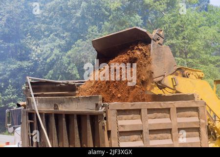 Le attrezzature da costruzione pesanti caricano la massa nel dumper di scarico utilizzando escavatori Foto Stock