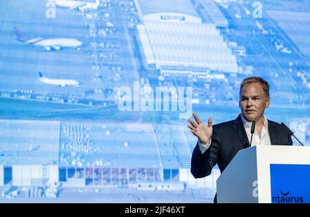 Schkeuditz, Germania. 29th giugno 2022. Sebastian Dietzmann, responsabile delle operazioni di Mytheresa, parla sul palco della cerimonia di consegna per una nuova sala logistica all'aeroporto di Lipsia/Halle. La società Mitheresa, con sede a Monaco di Baviera, è una piattaforma online per la moda di lusso e sta costruendo un moderno edificio logistico di circa 55.000 metri quadri a Schkeuditz, direttamente all'aeroporto. I primi 500 dipendenti dovrebbero iniziare a lavorare presso il centro logistico a metà del 2023. In totale, oltre 1.000 posti di lavoro saranno creati nel sito entro il 2030. Credit: Hendrik Schmidt/dpa/Alamy Live News Foto Stock