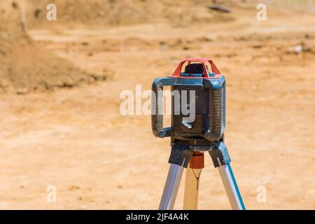 Durante la costruzione di strade, l'appaltatore usa la costruzione di laser dell'asta livellata Foto Stock