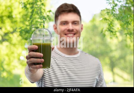 uomo che beve frullato verde da tazza usa e getta Foto Stock