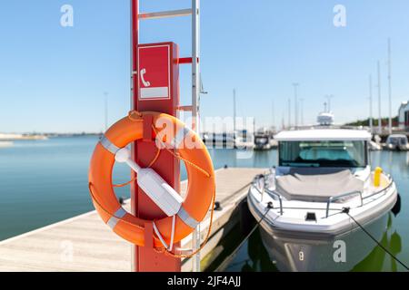 anello di vita o lifbuoy appeso sul palo all'ormeggio del mare Foto Stock