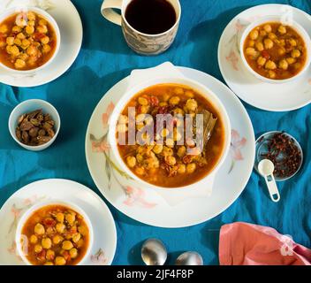 Vista dall'alto di Chana Masala o Choley o Chickpea saltata in burro o ghee su sfondo blu scuro. La salsa è spessa ha cipolla, pomodoro.Punjabi,pakistani. Foto Stock