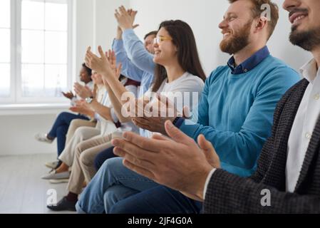 Gli uomini d'affari applaudiscono e applaudiscono a una riunione o conferenza, a un primo piano delle mani. Gruppo di uomini d'affari e donne in moderno ufficio bianco. Operazione riuscita Foto Stock