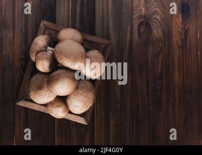 Funghi freschi champignon su tavola di legno, primo piano. Foto Stock