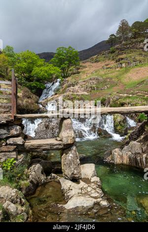 Passerella in pietra accanto alle cascate sul Watkin Path, una posizione ben nota nel parco nazionale Snowdonia, nel Galles del Nord. Foto Stock