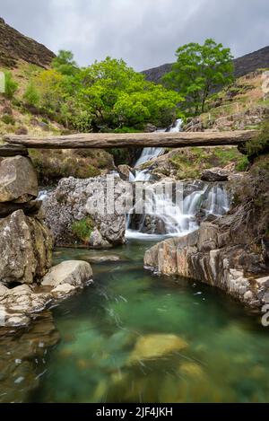 Passerella in pietra accanto alle cascate sul Watkin Path, una posizione ben nota nel parco nazionale Snowdonia, nel Galles del Nord. Foto Stock