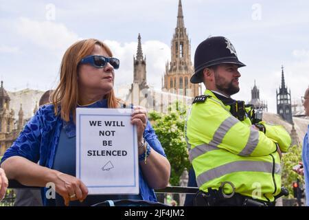 Londra, Regno Unito. 29th giugno 2022. Un manifestante ha un cartello con la dicitura "non saremo tacitati” accanto a un ufficiale di polizia. I dimostranti si sono riuniti in Piazza del Parlamento in solidarietà con l'attivista anti-Brexit Steve Bray il giorno dopo che ha fatto il suo sistema sonoro sequestrato dalla polizia, mentre la polizia, la criminalità, la condanna e la giustizia Bill sono entrate in vigore nel Regno Unito, limitando le proteste 'rumorose' e protestando contro le restrizioni. I manifestanti hanno suonato musica ad alto volume su un nuovo sistema audio. Credit: Vuk Valcic/Alamy Live News Foto Stock
