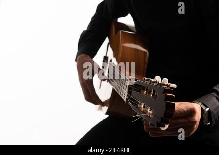 La chitarra classica e il chitarrista si sono soliti suonare su uno sfondo bianco con spazio di riproduzione Foto Stock