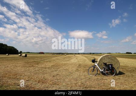 Paesaggio con campi raccolti e rotoli di fieno. Foto Stock