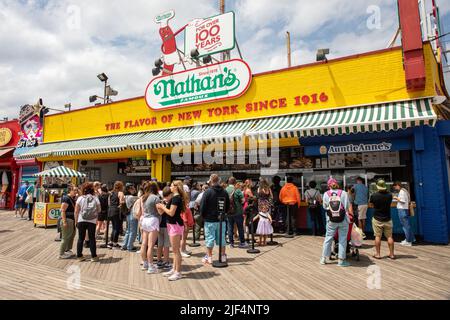 Persone che fanno la fila di fronte al famoso ristorante fast food Nathan nel parco divertimenti Coney Island nel quartiere di Brooklyn a New York, Stati Uniti Foto Stock