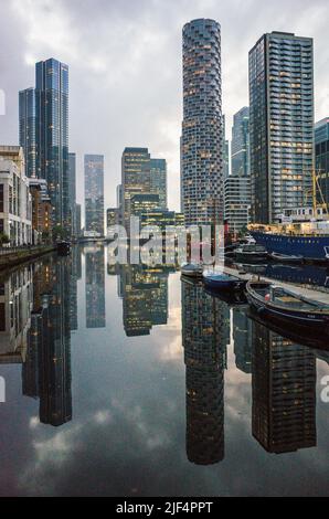 I grattacieli di Canary Wharf sull'Isola dei Dogs riflettono sul South Dock Water al tramonto, East London 2021. Foto Stock