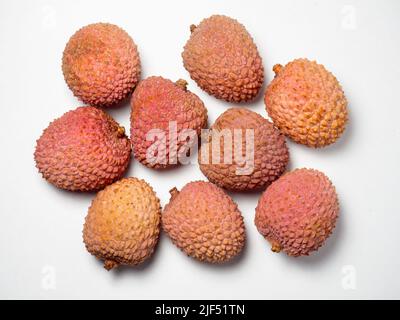 Lychee sul tavolo. Prugna cinese su sfondo bianco. Frutta matura dall'Asia. Prodotto delizioso e succoso. Foto Stock