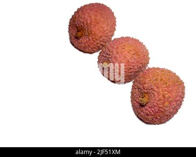 Lychee sul tavolo. Prugna cinese su sfondo bianco. Frutta matura dall'Asia. Prodotto delizioso e succoso. Foto Stock