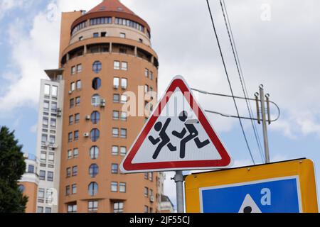 I segnali stradali avvertono che i bambini potrebbero essere sulla strada Foto Stock