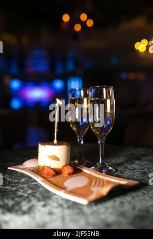 due bicchieri di vino frizzante e dessert al tiramisù sul tavolo Foto Stock
