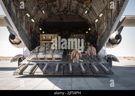 Gli airman degli Emirati Arabi Uniti con 16th Airlift Squadron, UAE Air Force, preparano un aereo dell'UAE Air Force C-17 Globemaster per ricevere equipaggiamento supplementare al Marine Corps Air Ground Combat Center, Twentynine Palms, California, 25 febbraio 2022. Il corpo Marino degli Stati Uniti e gli Emirati Arabi Uniti mantengono una stretta relazione attraverso impegni e programmi di formazione bilaterali persistenti, migliorando la capacità reciproca di condurre operazioni antiterrorismo, proteggere infrastrutture critiche e sostenere la difesa nazionale (U.S.A. Foto del corpo marino di CPL. Therese Edwards) Foto Stock