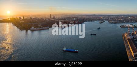 Panorama: Vista aerea delle navi ancorate e ancorate al porto industriale al tramonto Foto Stock