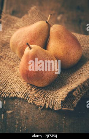 Pere fresche mature su tavola di legno in stile vintage. Raccolta autunnale. Foto Stock