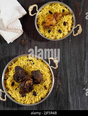 Vista dall'alto riso arabo, kebuli con costolette di lam e pollo speziato. Su tavola in legno con spazio di copia per testo Foto Stock