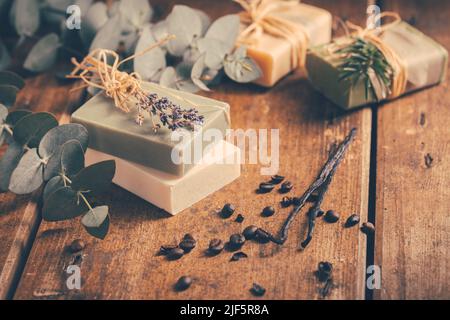 Saponette naturali organiche con vaniglia, chicchi di caffè ed eucalipto su sfondo di legno Foto Stock