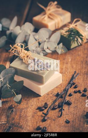 Saponette naturali organiche con vaniglia, chicchi di caffè ed eucalipto su sfondo di legno Foto Stock