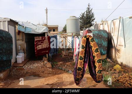 Coperte e vestiti si asciugano al sole. Una mattina in un campo profughi nella valle di Bekaa vivono circa 20 famiglie. Alcune famiglie attendono da cinque anni di andare in un altro luogo. Anche se la situazione permettesse loro di tornare in Siria, la maggior parte di loro solo canít. I bambini nati in Libano non hanno un passaporto siriano, ma sono registrati nel paese. Pertanto i genitori soggiornano anche nel paese. Molti genitori hanno anche il loro permesso di soggiorno scaduto e non possono permettersi di avere un nuovo rilasciato, come molti vivono su due o tre dollari al giorno. Foto Stock