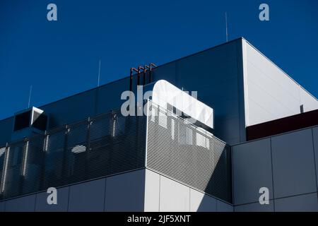 Impianti di ventilazione e aria condizionata sul tetto di un edificio moderno. Il sistema HVAC è stato fotografato contro un cielo blu in un pomeriggio soleggiato Foto Stock