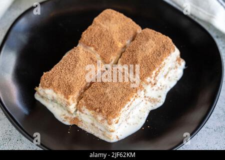 Baklava freddo. Baklava con latte su sfondo bianco. Specialità della cucina turca. Primo piano Foto Stock