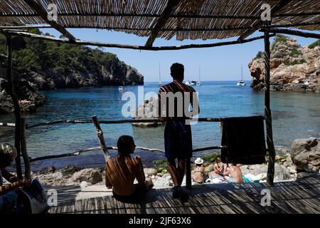 Deia, Spagna. 29th giugno 2022. I bagnanti possono godersi la giornata presso la spiaggia rocciosa Cala Deia di Maiorca. Credit: Clara Margais/dpa/Alamy Live News Foto Stock