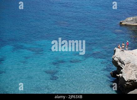 Deia, Spagna. 29th giugno 2022. I turisti prendono il sole e nuotano presso la spiaggia rocciosa Cala Deia di Maiorca. Credit: Clara Margais/dpa/Alamy Live News Foto Stock