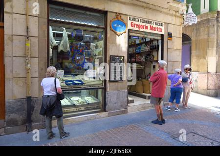 I turisti ammirano la vetrina di Gregorio Martin, un tradizionale negozio di merluzzo salato ad Artekale, nel centro storico della città spagnola di Bilbao Foto Stock