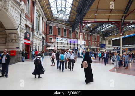 LONDRA, Regno Unito - 15 LUGLIO 2019: I passeggeri visitano la stazione Victoria di Londra. La stazione di Victoria serve oltre 73 milioni di viaggiatori ogni anno. Foto Stock