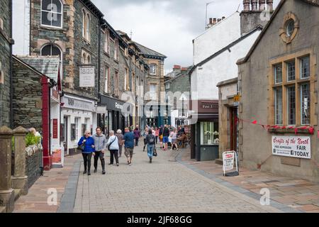 I visitatori passeggiano per le strade dello shopping della città di Keswick, nel Lake District, in Cumbria Foto Stock