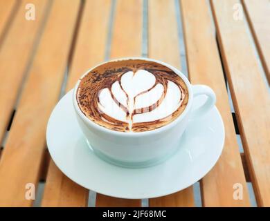 Caffè ad alta angolazione latte art su tavolo in legno nella caffetteria Foto Stock