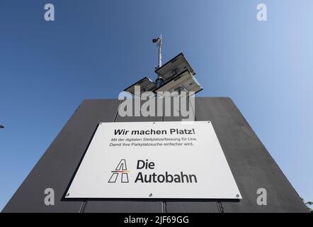 Medenbach, Germania. 30th giugno 2022. Un sistema di sensori per il rilevamento dei parcheggi gratuiti nell'area di riposo Medenbach del A3 è alimentato da pannelli solari. Nell'ambito di un progetto pilota, gli spazi di parcheggio gratuiti per i veicoli industriali vengono ora registrati da sensori e trasmessi ai conducenti tramite APP. Ciò ha lo scopo di semplificare la ricerca di posti di parcheggio gratuiti. Credit: Boris Roessler/dpa/Alamy Live News Foto Stock