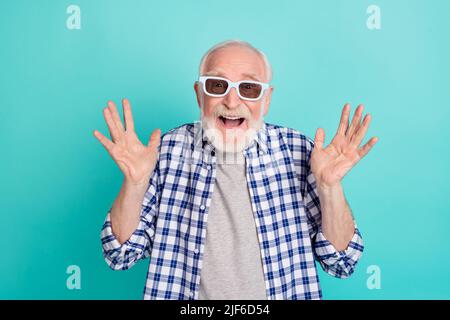 Foto di nonno anziano che guarda il divertente film indossando 3D occhiali isolati su sfondo di colore turchese Foto Stock