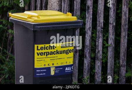 Lipsia, Germania. 30th giugno 2022. Un cosiddetto rifiuti giallo può per rifiuti di plastica leggera come l'imballaggio si trova su una piccola strada in una tenuta di alloggiamento in un giorno di svuotamento. L'Istituto dell'economia tedesca (Institut der deutschen Wirtschaft) ha calcolato, per l'associazione dei proprietari di immobili Haus und Grund, che esiste un divario significativo tra le spese di smaltimento dei rifiuti nelle principali città tedesche. Credit: Jan Woitas/dpa/Alamy Live News Foto Stock