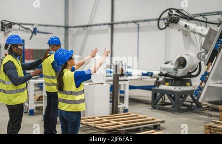 Ingegneri multietnici che utilizzano occhiali futuristici per realtà aumentata all'interno di una fabbrica robotica - Focus on Woman Face Foto Stock