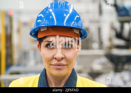 Donna ingegnere senior che lavora all'interno di una fabbrica robotica - Focus on Face Foto Stock