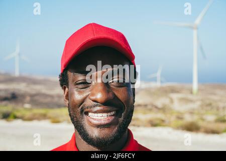 Uomo africano che lavora ad una fattoria mulino a vento - Focus on Face Foto Stock