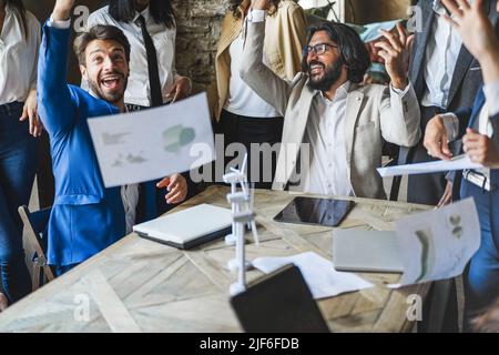 Happy business persone che festeggiano il successo del progetto di energia rinnovabile in ufficio - Focus on arab man gettando carte Foto Stock