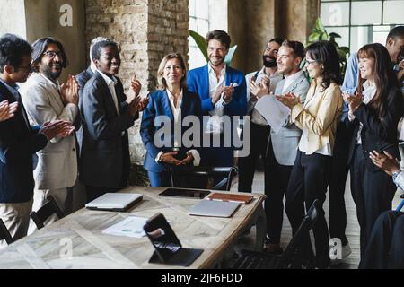 Uomini d'affari multirazziali che festeggiano insieme all'interno dell'ufficio - Focus on african woman face Foto Stock