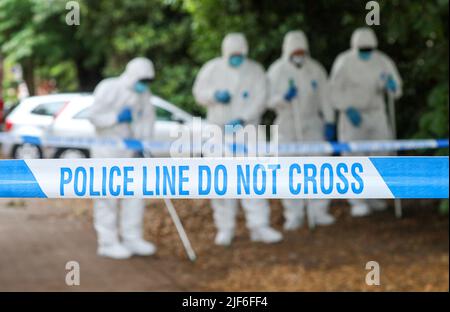 Nastro di polizia in una scena di crimine nel Regno Unito come scene di ufficiali di crimine che seccano. Foto Stock