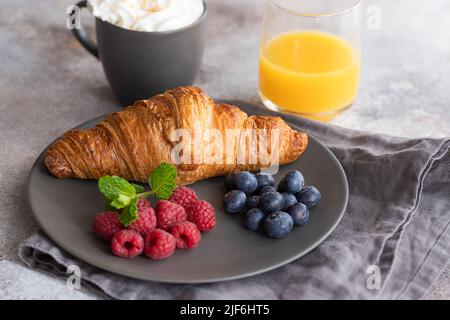 Colazione continentale, croissant alla francese, caffè con latte, frutta e succo d'arancia. Buon concetto di mattina. Foto Stock