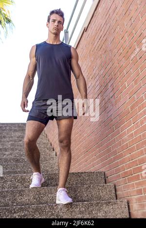 Atleta che cammina lungo le scale di uno stadio stand Foto Stock