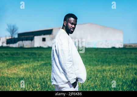 Vista posteriore di imprenditore positivo giovane donna in cappotto nero in piedi con sacco nero mentre si cammina il ponte Foto Stock