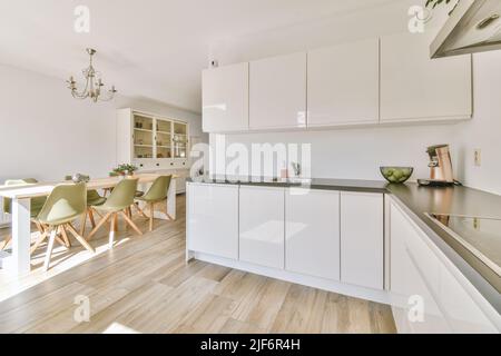 interno di una cucina piccola e leggera con mobili bianchi dallo stile minimalista con lavandino Foto Stock