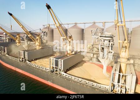 ODESSA, UCRAINA - 9 agosto 2021: Caricamento di grano in stive di nave da carico via mare attraverso una linea automatica in porto marittimo da silos di deposito di grano. Bunke Foto Stock