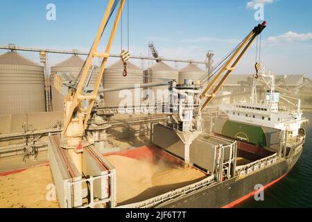 ODESSA, UCRAINA - 9 agosto 2021: Caricamento di grano in stive di nave da carico via mare attraverso una linea automatica in porto marittimo da silos di deposito di grano. Bunke Foto Stock