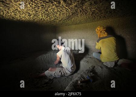 Operai che scavano e intagliano attraverso la roccia per costruire una camera per la tomba tradizionale camera di pietra a Nord Toraja, Sulawesi Sud, Indonesia. Foto Stock